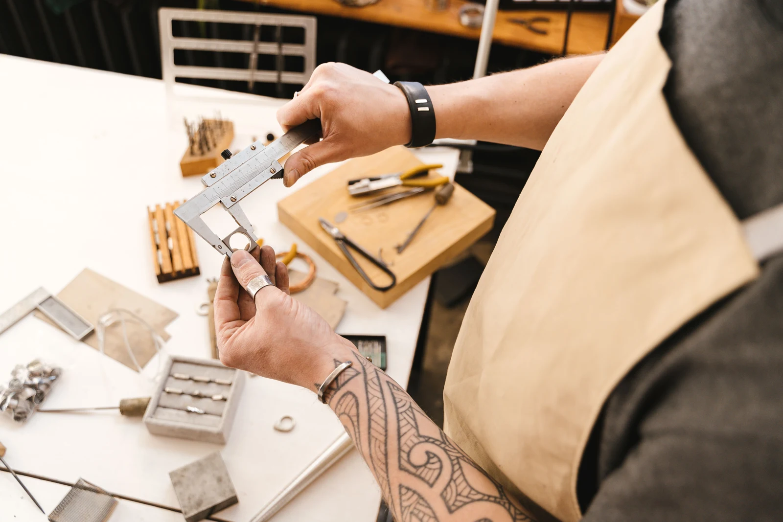 Hands using a vernier caliper to check the dimensions of a metal item